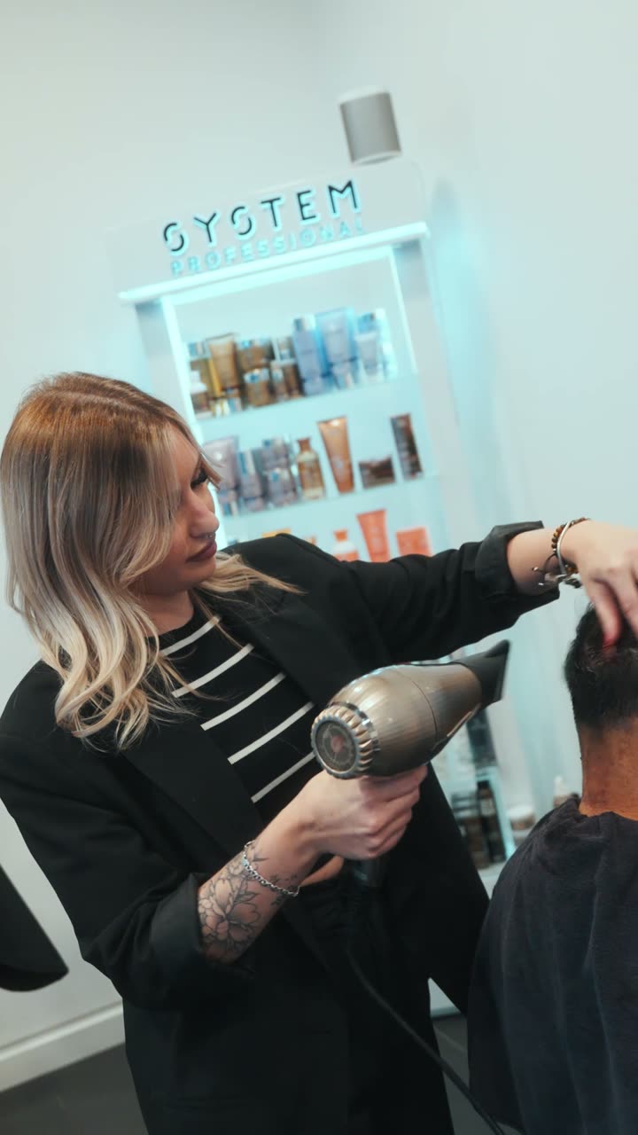 Coiffeuse au travail dans un institut de beauté, séchage après un soin.